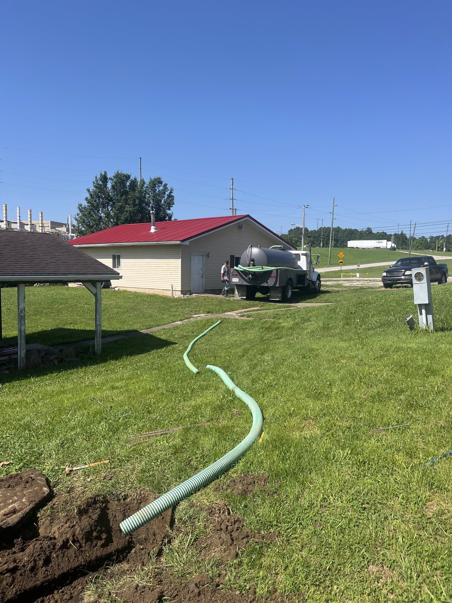 Pump truck on-site at a rural Indiana property with hose running to tank