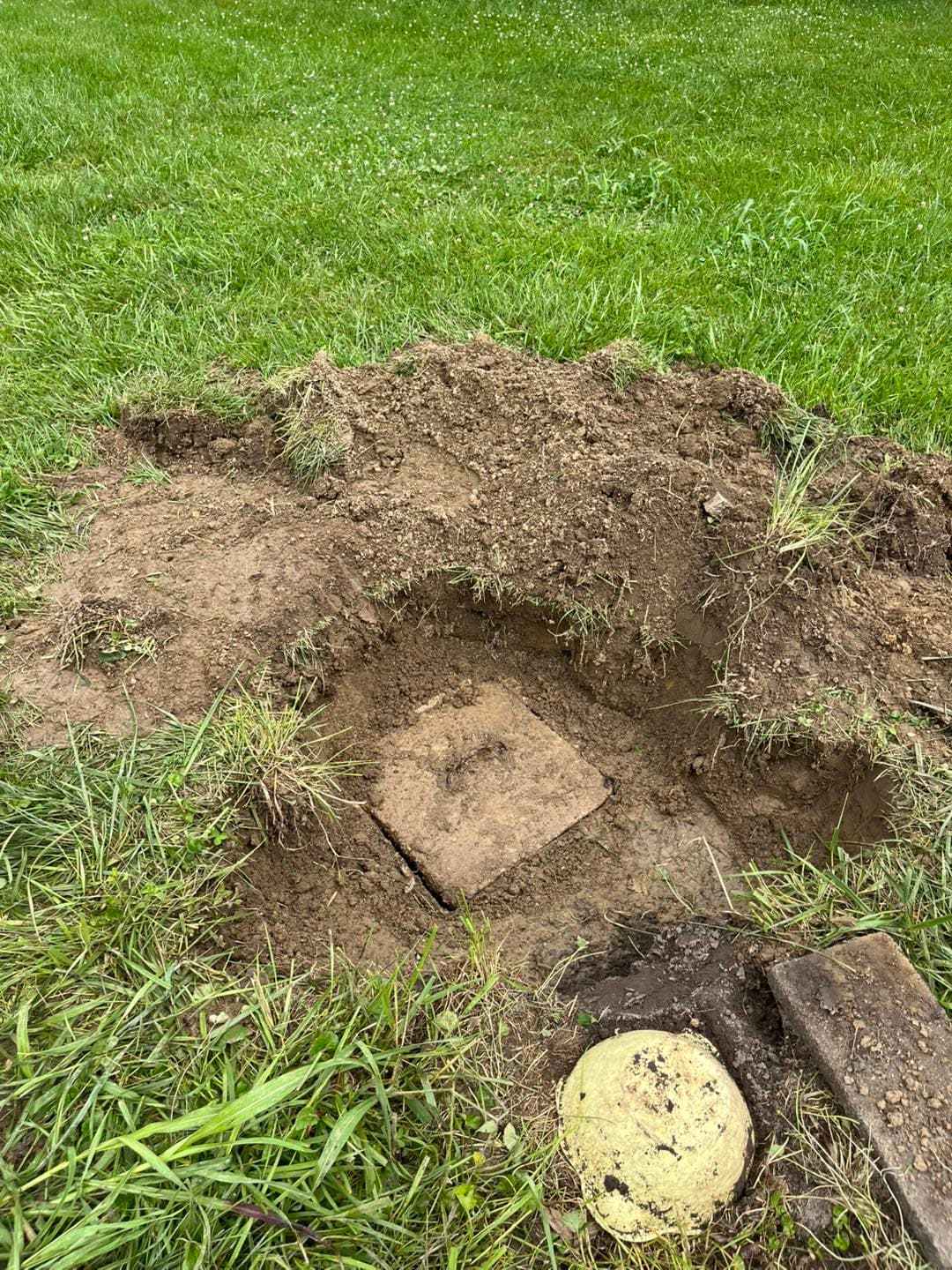 Excavated concrete septic tank lid before riser installation
