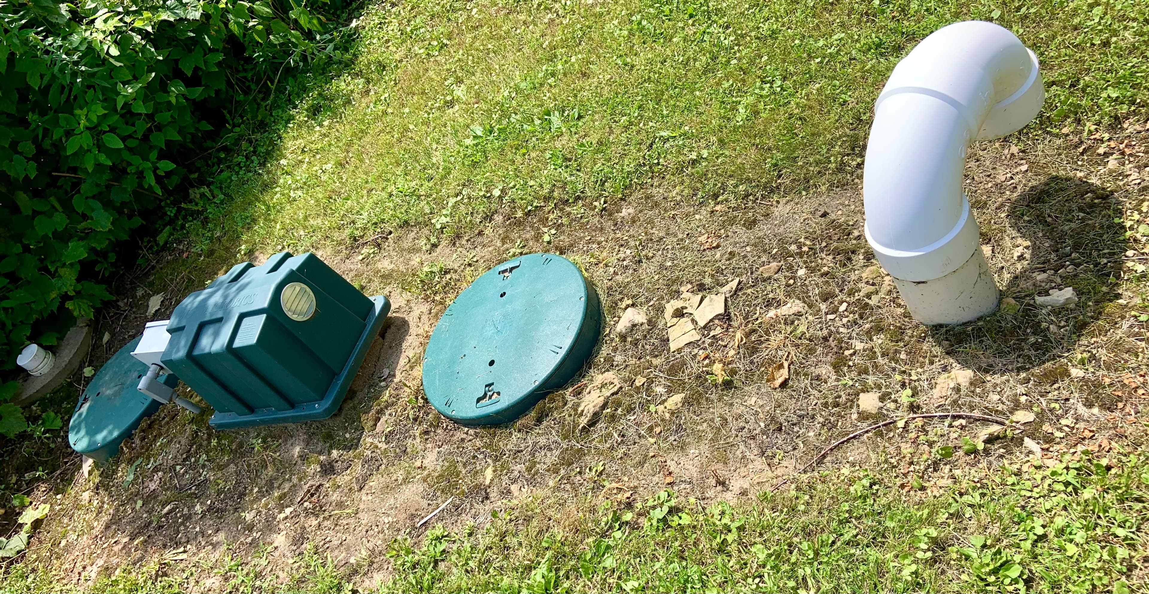A residential concrete septic tank with its access lids exposed at ground level