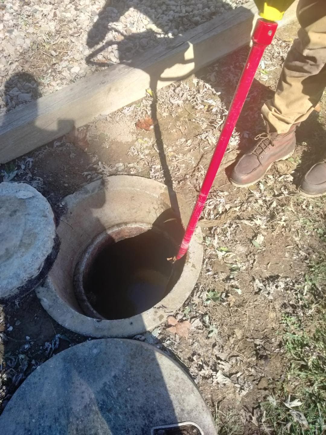 Close-up view of crud buster in an open septic tank during repair work